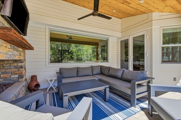 Covered outdoor living room with stone fireplace